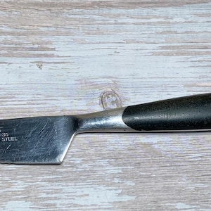 May include: A set of three ceramic mugs with a speckled, matte finish. The mugs are in shades of cream, light brown, and dark brown. Each mug has a simple, minimalist design and a rounded handle.