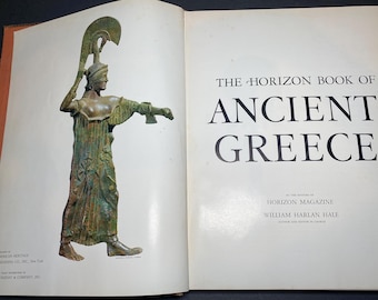 以下が含まれることがあります： 「The Horizon Book of Ancient Greece」というタイトルの開いた本。古代ギリシャの衣装を着た人物のブロンズ像が左ページにあります。像は武器を持ち、ヘルメットをかぶっています。本のタイトルは大きく太字で書かれています。