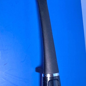 May include: Black Farberware ladle with a long handle and a deep, rounded bowl. The handle has a silver accent and the Farberware logo. The ladle is made of a matte black material.