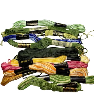 May include: A collection of J.P. Coats and DMC embroidery floss skeins in various colors including light green, dark green, blue, yellow, orange, and pink. Each skein features a black paper label with printed text, barcodes, and color codes.