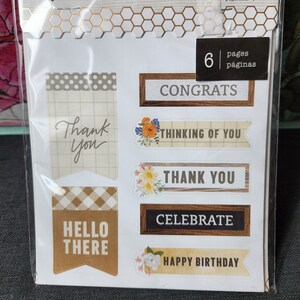 May include: A package of 42 stickers with a variety of designs, including "Thank You", "Hello There", "Congrats", "Thinking of You", "Celebrate", and "Happy Birthday". The stickers are on 6 pages and are made by Jen Hadfield.