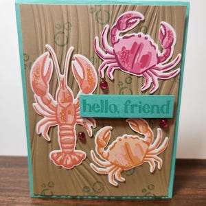Tarjeta de felicitación hecha a mano con texto "Hola amigo", criaturas marinas