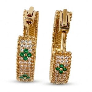 May include: A pair of gold hoop earrings featuring a textured beaded edge and a central row of clear pavé-set stones. Each hoop is accented with two four-leaf clover motifs composed of four small, round, vibrant green stones set in gold.