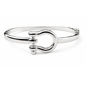 May include: A polished silver-tone bangle bracelet featuring a central horseshoe-shaped clasp mechanism. The bracelet has a smooth, rounded band design with a hinged closure on one side and a secure locking mechanism integrated into the front.