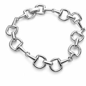 May include: A polished silver-tone metal chain bracelet featuring a repeating horsebit link design. The bracelet is constructed from interconnected, smooth, curved metal segments that form a continuous circular loop with a secure clasp closure.