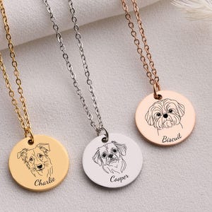 May include: Three dog-themed pendant necklaces. One is gold-toned with a dog portrait and the name "Charlie." Another is silver-toned with a dog portrait and the name "Cooper." The third is rose gold-toned with a dog portrait and the name "Biscuit."