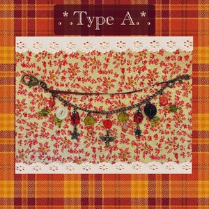 May include: A charm bracelet featuring ladybug, flower, and bee charms. The bracelet is set against a floral backdrop, with the text "Type A." displayed above.