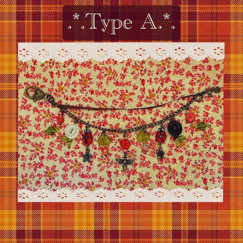 May include: A charm bracelet featuring ladybug, flower, and bee charms. The bracelet is set against a floral backdrop, with the text "Type A." displayed above.
