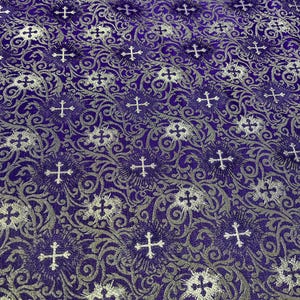 May include: Purple fabric with a silver brocade pattern of crosses and floral designs.