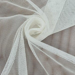 K&ouml;nnte beinhalten: Nahaufnahme von wei&szlig;em T&uuml;llstoff mit einem netzartigen Muster. Der Stoff ist drapiert und gefaltet, wodurch ein strukturierter Effekt entsteht. Das Material ist leicht und halbtransparent, geeignet f&uuml;r verschiedene Bastelprojekte.