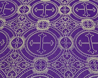 May include: Close-up of a purple fabric with a repeating pattern of gold crosses and circular designs. The crosses are within circles, and the background is a solid purple color. The fabric has a textured appearance.