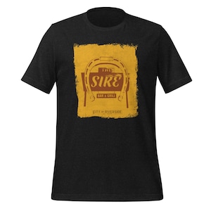 May include: Black t-shirt featuring a yellow and brown graphic of a horseshoe with the text "The Sire Bar & Grill City of Riverside" printed on it.