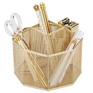 May include: A gold-colored metal mesh desk organizer with multiple compartments. The organizer contains gold pens, pencils, a stapler, scissors, and a ruler. The pencils and ruler have crown accents. The organizer is designed to hold office supplies.