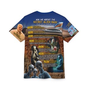 Op de afbeelding: Een blauw T-shirt met een grafische print van een geheime alienbasis onder Dulce, New Mexico. De grafiek bevat een kaart van de basis met verschillende niveaus en beschrijvingen van elk niveau. De tekst op het shirt luidt "Ask me about the Secret Alien Base Under Dulce New Mexico".