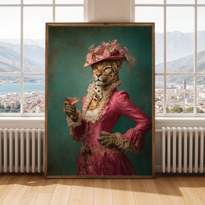 Puede incluir: Una impresión artística enmarcada que presenta un leopardo con cuerpo humano, vestido con un vestido y sombrero rosa, sosteniendo un cóctel. La obra de arte tiene una estética vintage con un fondo verde azulado y un marco de madera. La cara del leopardo es detallada.