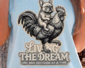 Französische Bulldogge reitet Hahn T-Shirt | Grafik-T-Shirt „Living The Dream“