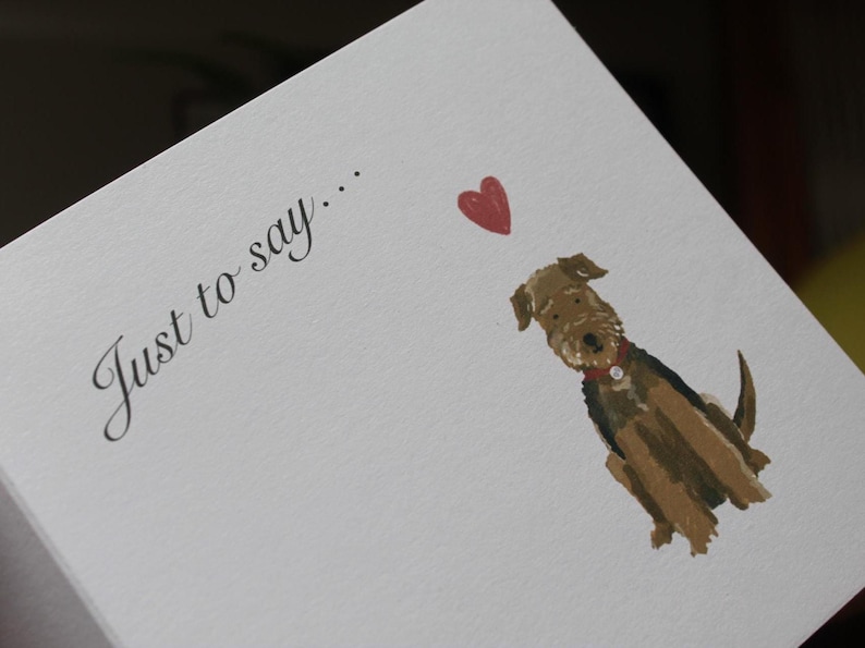 K&ouml;nnte beinhalten: Wei&szlig;e Karte mit dem Text "Just to say..." in Schreibschrift. Eine Aquarellillustration eines braun-schwarzen Hundes mit rotem Halsband und rotem Herz.