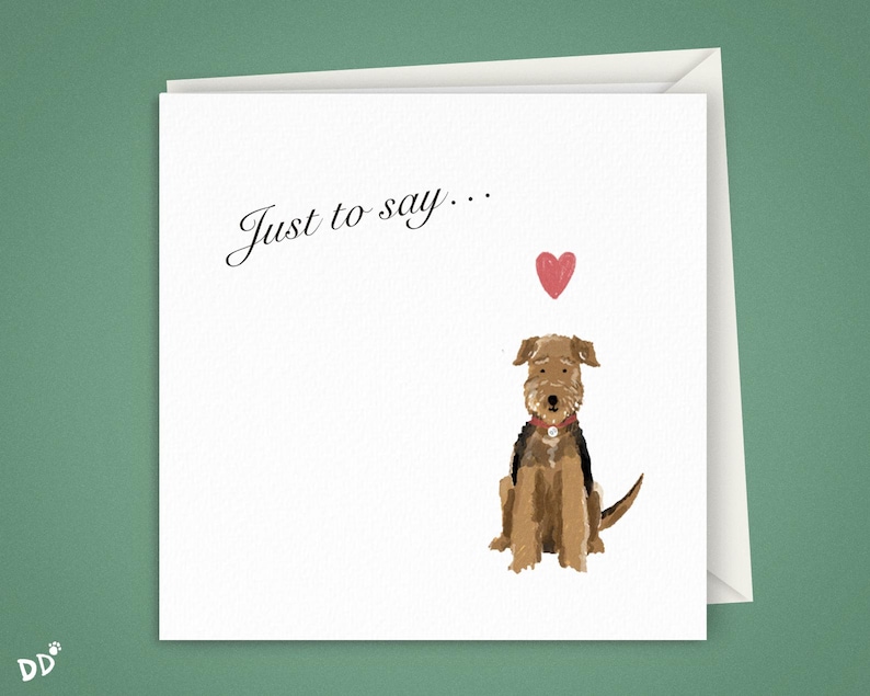 K&ouml;nnte beinhalten: Quadratische Gru&szlig;karte mit dem Text "Just to say..." in Schreibschrift. Die Karte zeigt eine Aquarellillustration eines braunen und schwarzen Hundes mit rotem Halsband und einem kleinen roten Herz dar&uuml;ber. Die Karte befindet sich in einem wei&szlig;en Umschlag.