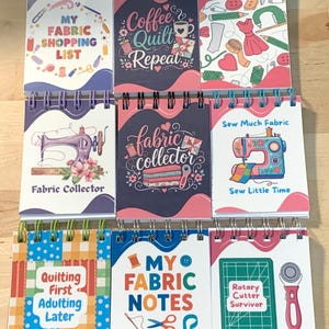 May include: A collection of nine spiral-bound notebooks featuring colorful sewing and quilting-themed illustrations and text, including phrases like My Fabric Shopping List, Coffee Quilt Repeat, Fabric Collector, Sew Much Fabric, and Quilting First.