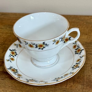 vintage yong shen teacup and saucer. yellow floral design and gold trim