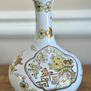 Imari vase with cart design and elaborate floral pattern with gold accents.