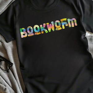 May include: Black t-shirt with the word "BOOKWORM" printed in rainbow colors.