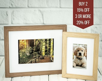 May include: Two wood picture frames with white mats. The larger frame has a photo of a forest path with tall trees. The smaller frame has a photo of a golden retriever puppy. The text "BUY 2 15% OFF 3 OR MORE 20% OFF" is in a red box in the upper right corner of the image.