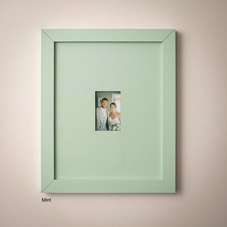 A framed photograph of a couple, likely a bride and groom, is displayed on a light green wall.