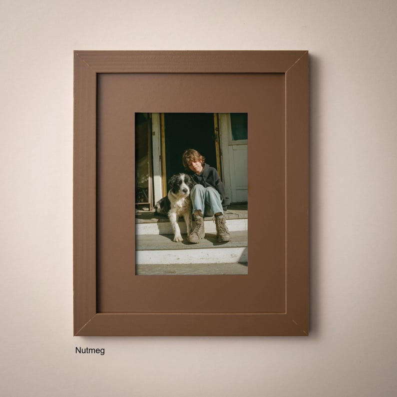 A framed photograph of a person sitting on a porch with a dog, both looking at the camera.