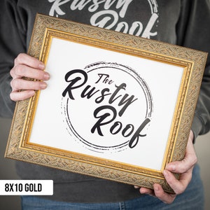 May include: A gold-colored frame with a white mat and a black and white logo that says "The Rusty Roof". The frame is 8x10 inches.