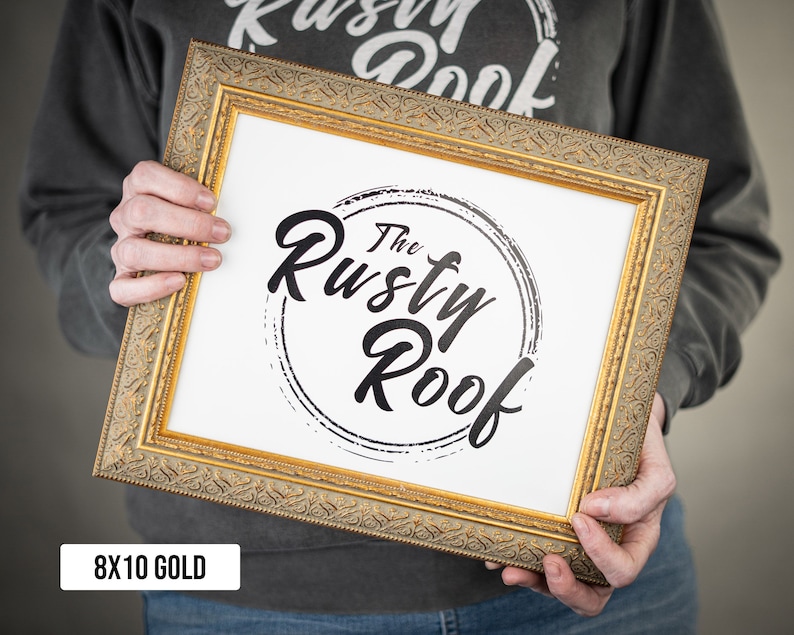 May include: A gold-colored frame with a white mat and a black and white logo that says "The Rusty Roof". The frame is 8x10 inches.