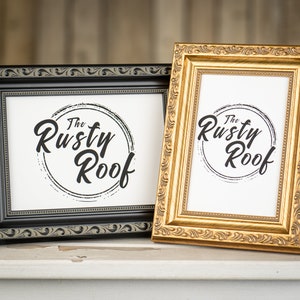 May include: Two picture frames, one black and one gold, with ornate detailing. Both frames feature a white background with the text "The Rusty Roof" in black.