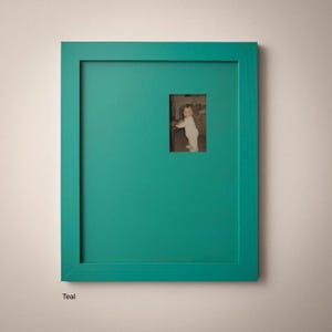 a small child standing in a room with a green frame.