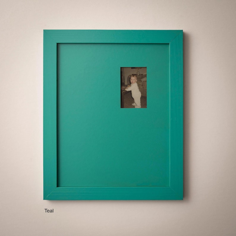 a small child standing in a room with a green frame.