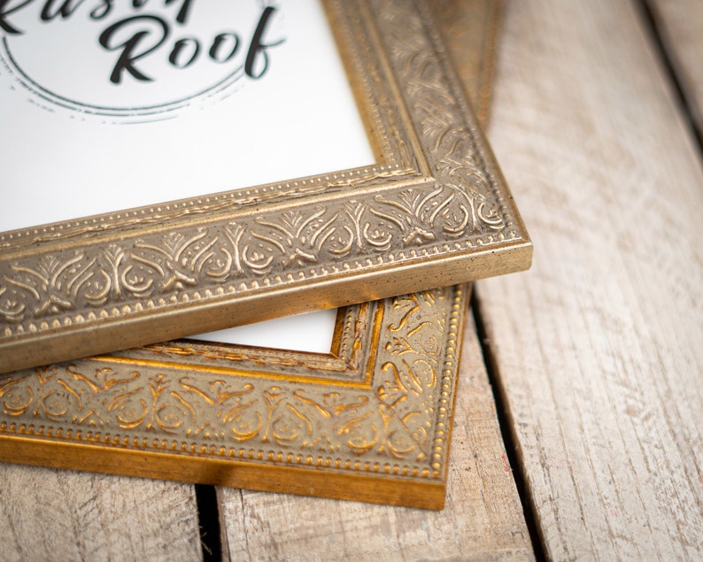 May include: Two ornate gold picture frames with intricate designs. The top frame has the text "Rustic Roof" printed on the white mat.