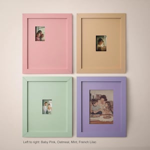 four framed pictures arranged in a grid on a wall, each with a different color frame.