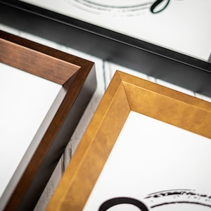May include: Three picture frames in different sizes and colors. The largest frame is black, the middle frame is brown, and the smallest frame is gold.