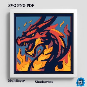 May include: A framed, multilayered shadowbox art piece featuring a red and orange dragon with flames against a blue background. The artwork is in a white frame. Text at the top reads "SVG PNG PDF", and at the bottom, "Multilayer Shadowbox".
