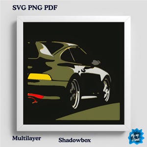 Pode incluir: Impressão emoldurada com uma ilustração estilizada de um carro esportivo em tons de verde, preto e branco. O carro tem um spoiler e está em um fundo escuro. A impressão inclui o texto "SVG PNG PDF", "Multilayer" e "Shadowbox".