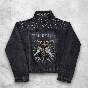 Könnte beinhalten: Schwarze Jeansjacke mit Perlenbesatz auf den Schultern. Auf der Rückseite befindet sich der gestickte Schriftzug "TILL DEATH" über einem Design aus Skeletthänden und das Datum "06.10.2025" auf dem Kragen. Die Jacke hat ein klassisches Design.