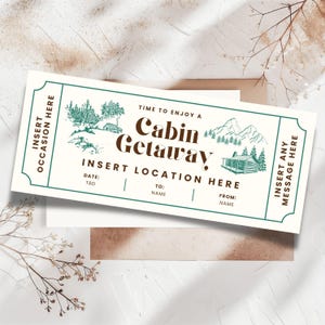 K&ouml;nnte beinhalten: Ein cremefarbenes Ticket mit gr&uuml;nem Rand und dem Text "Cabin Getaway". Das Ticket zeigt Illustrationen von B&auml;umen, Bergen und einer H&uuml;tte. Es enth&auml;lt Felder zum Einf&uuml;gen von Datum, Ort und einer pers&ouml;nlichen Nachricht.