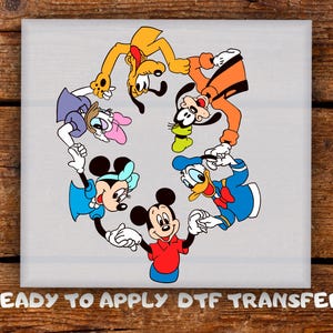 May include: A DTF transfer featuring a circular arrangement of cartoon characters, including Mickey Mouse, Minnie Mouse, Donald Duck, Goofy, and Pluto. The characters are in bright colors against a gray background. The text "READY TO APPLY DTF TRANSFER" is at the bottom.