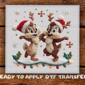 May include: Embroidered image of two cartoon chipmunks wearing Santa hats and reindeer antlers, dancing on a snow-covered surface with Christmas lights. The image is on a white background with the text "READY TO APPLY DTF TRANSFER".