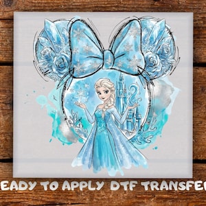 May include: A light blue watercolor design featuring Elsa from Frozen, within a Mickey Mouse ear outline. The design includes a bow with snowflake accents, ice crystals, and a castle. The text "READY TO APPLY DTF TRANSFER" is at the bottom.