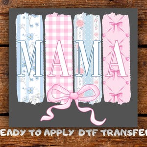 May include: A gray graphic with the word "MAMA" in white block letters. Each letter is set against a different pastel background: blue floral, pink gingham, blue lace, and pink bows. A pink bow is at the bottom. The text "READY TO APPLY DTF TRANSFER" is at the bottom.