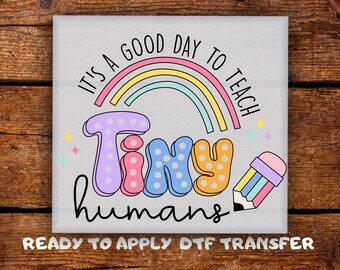 May include: A square, light gray graphic with the text "It's a good day to teach Tiny humans" in colorful bubble letters and a rainbow. A pencil illustration is on the right. The words "READY TO APPLY DTF TRANSFER" are at the bottom.
