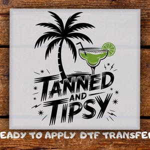 May include: White square graphic featuring a black palm tree, a green margarita, and the words "TANNED AND TIPSY". The design includes stars and lightning bolts. The text "READY TO APPLY DTF TRANSFER" is at the bottom.