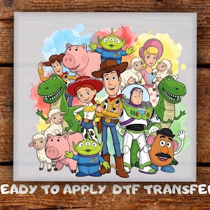 May include: A colorful DTF transfer featuring a group of cartoon characters, including a cowboy, a space ranger, and a dinosaur. The characters are set against a watercolor background with the text "READY TO APPLY DTF TRANSFER".