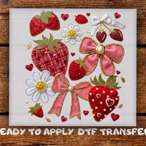 May include: A square fabric design featuring strawberries, bows, and daisies. The strawberries are red with green leaves, some with plaid patterns. Pink and white bows with gold trim and pearl accents are also present. The text "READY TO APPLY DTF TRANSFER" is at the bottom.