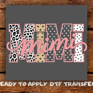May include: A gray background with the word "Mimi" in pink script. The letters are filled with various patterns, including leopard print, crosses, and polka dots. The text "READY TO APPLY DTF TRANSFER" is at the bottom.